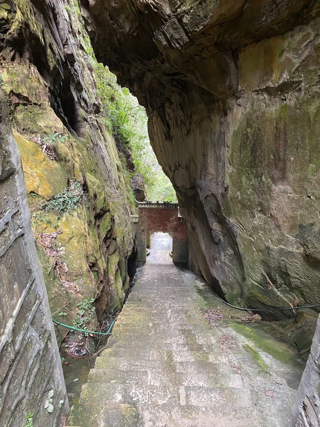 The narrow stone path under an overhang leading to the small brick gateway of the Yingwozhai stronghold above Baofeng Lake.