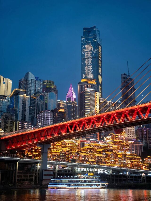 Chongqing city skyline lit up at night above the river confluence.