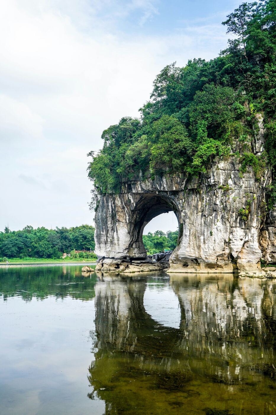 Elephant Trunk Hill mirrored in the Li River at Guilin, its rock arch resembling an elephant drinking.