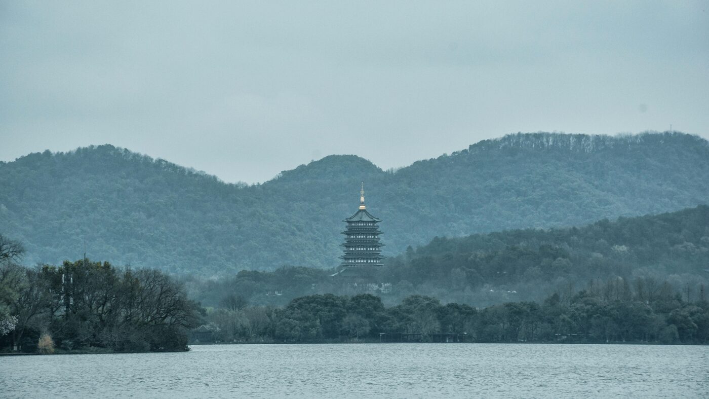 Panorama of West Lake in Hangzhou — open water, distant hills and a lakeside causeway.