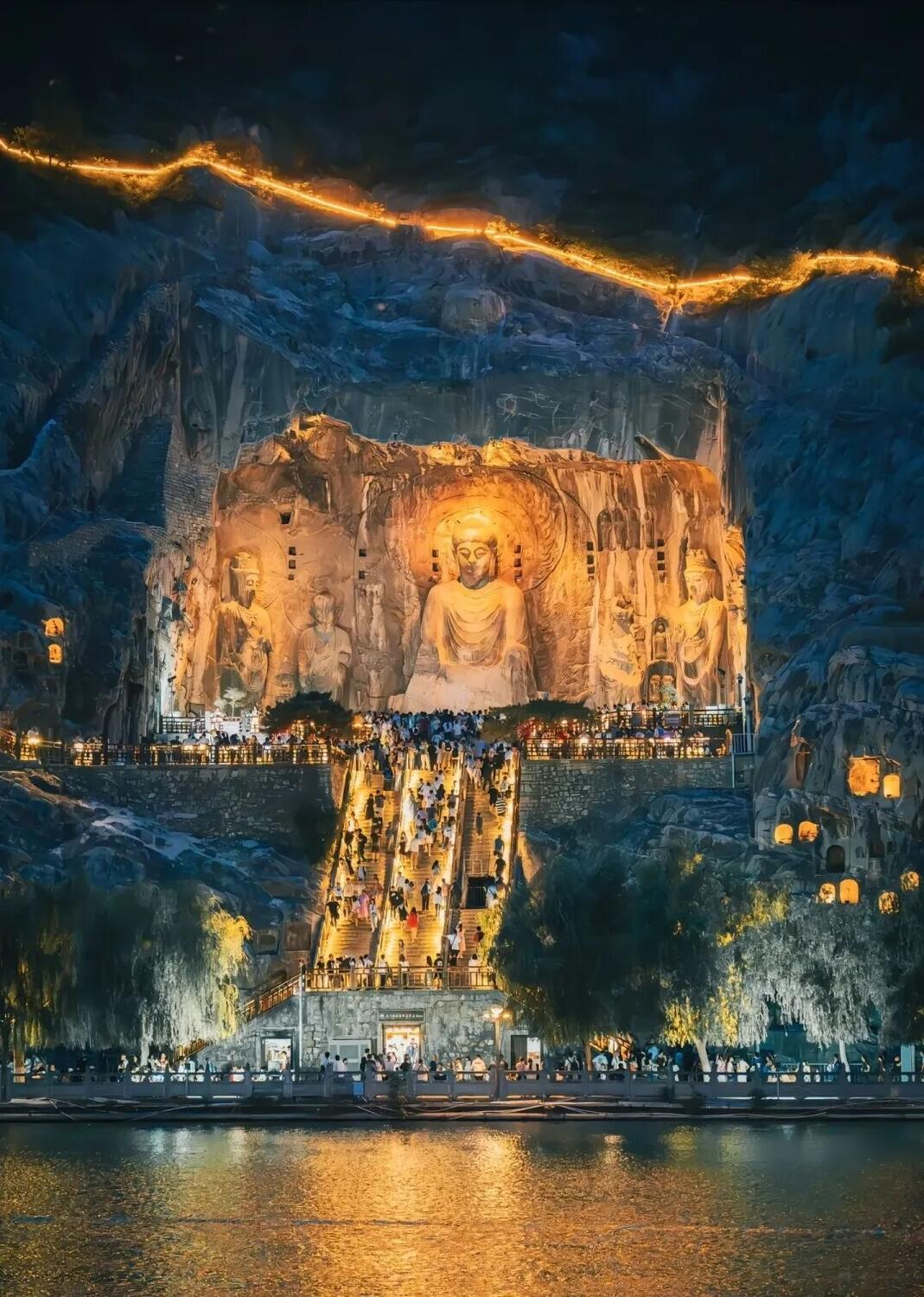 Rows of carved Buddhist niche statues set into the limestone cliff at the Longmen Grottoes, Luoyang.