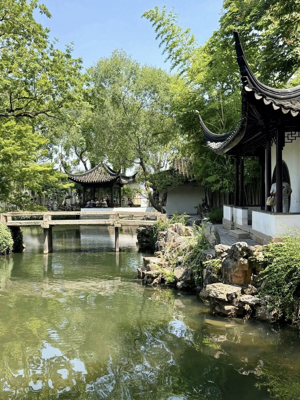 A pavilion and Taihu-rock composition reflected in a still pond at a classical Suzhou garden.