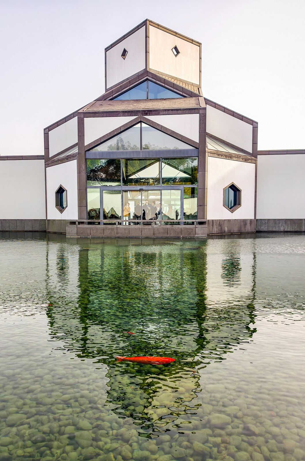 Interior courtyard of the Suzhou Museum with white walls, a pond and the geometric architecture of I.M. Pei's design.
