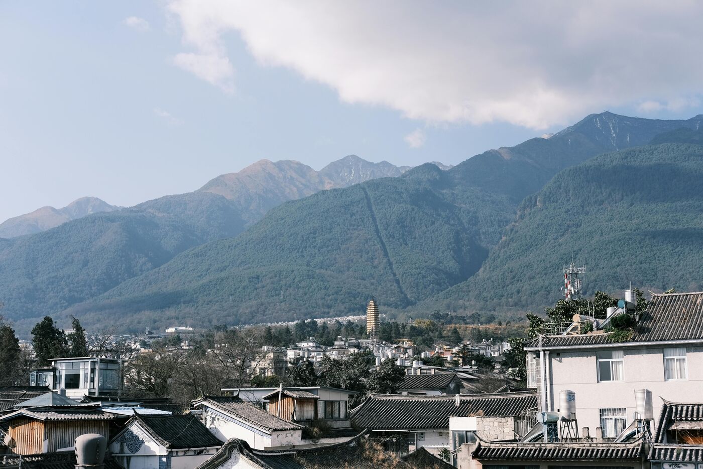 Dali Old Town in Yunnan — a stone town gate and tiled rooftops beneath the Cangshan range.