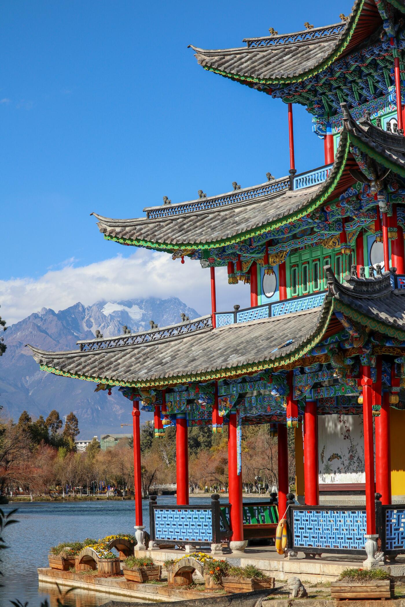 A canal and stone bridge among the timber shopfronts of Lijiang Old Town, Yunnan.