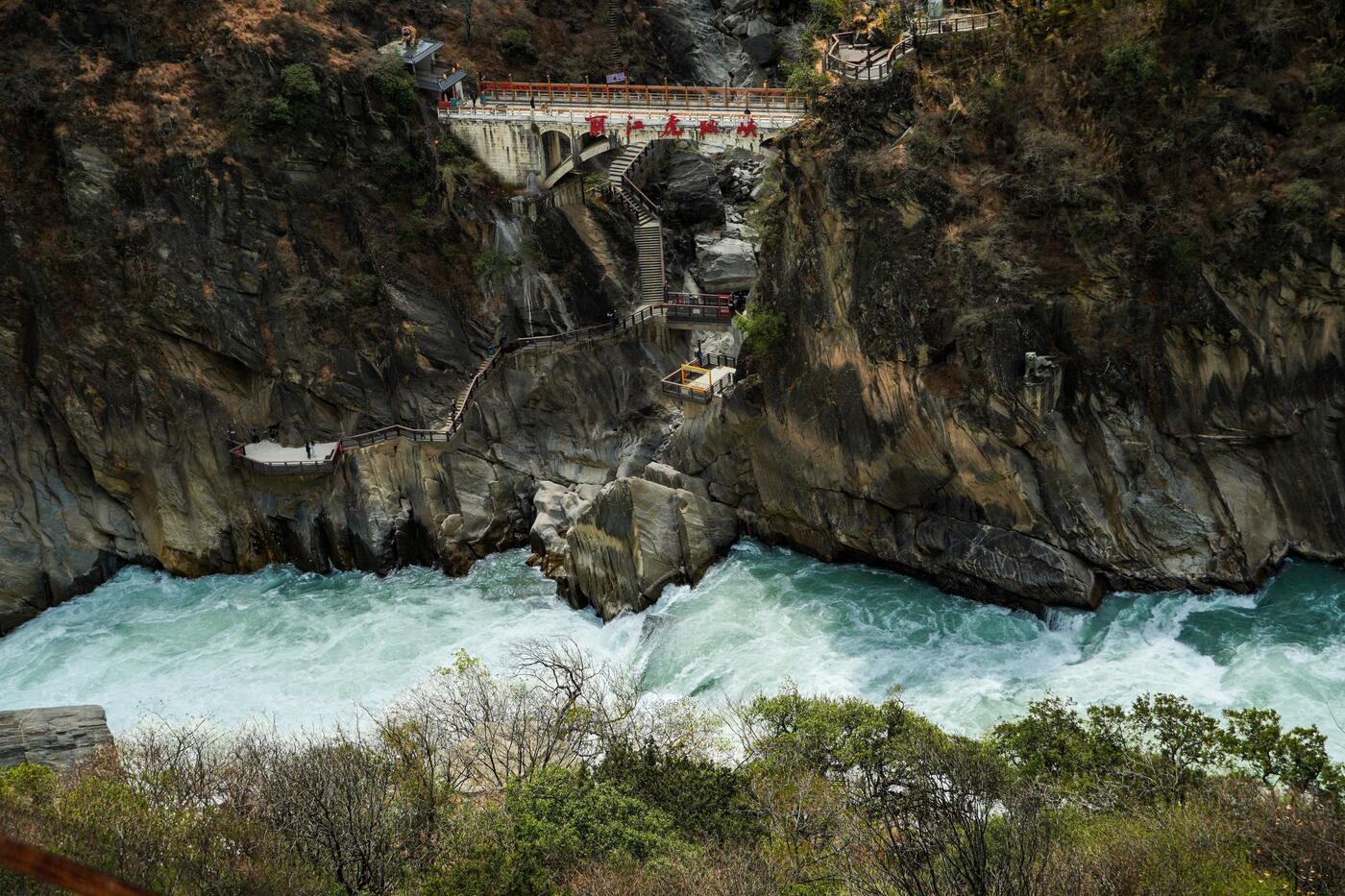 The high trail above Tiger Leaping Gorge, Yunnan, with the river far below and terraced slopes.