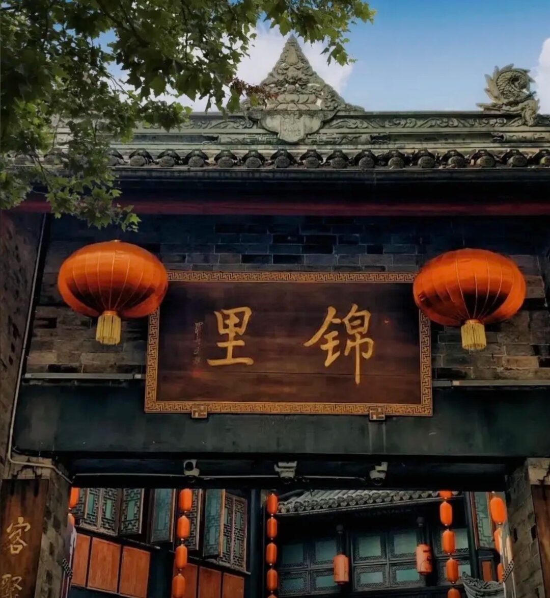 The Jinli (锦里) gate with red lanterns and carved grey-tile eaves beside the Wuhou Temple in Chengdu.