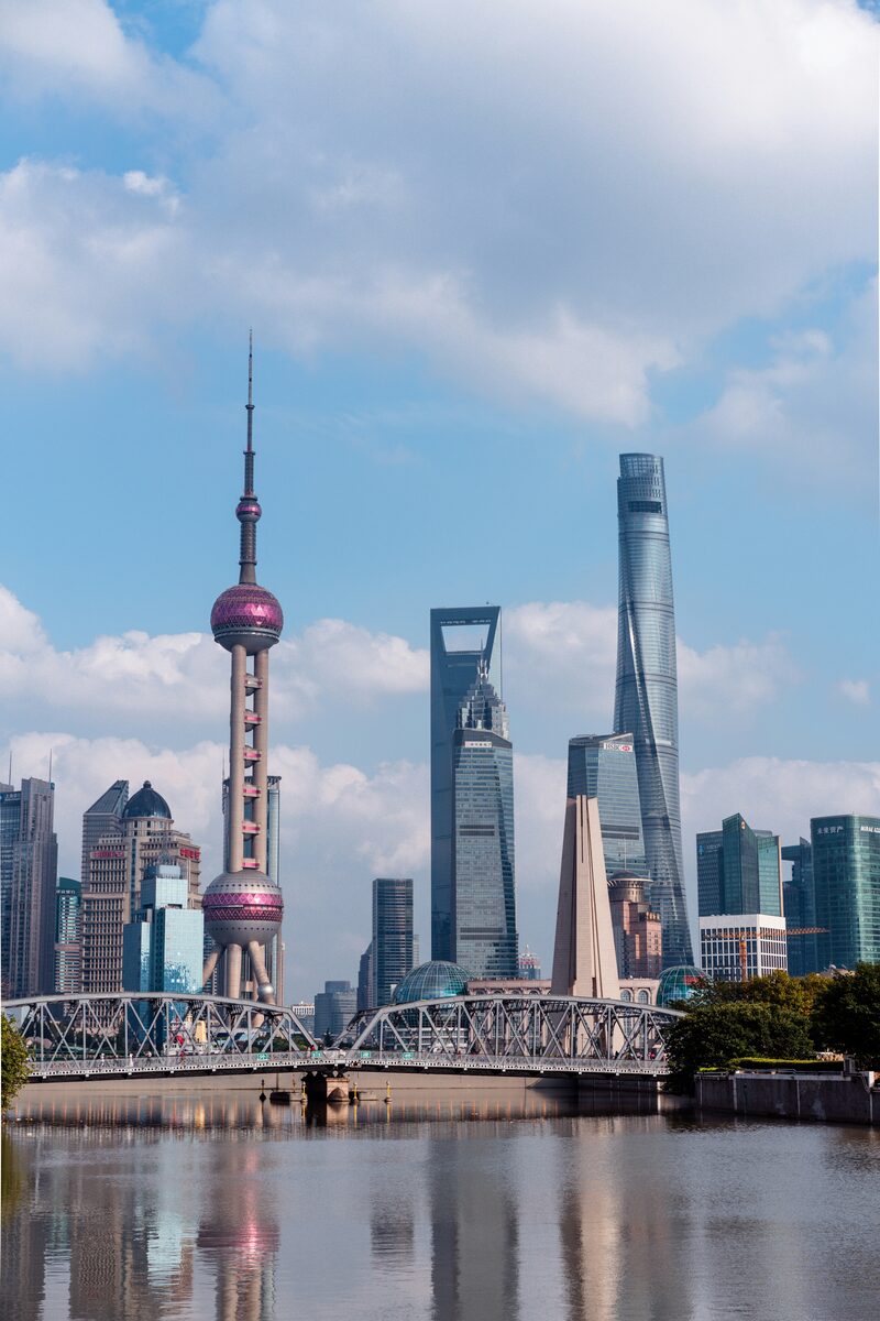 Pudong skyline Shanghai — Oriental Pearl Tower, Shanghai World Financial Center and Shanghai Tower rising above the Huangpu River, with the Waibaidu Bridge in the foreground.