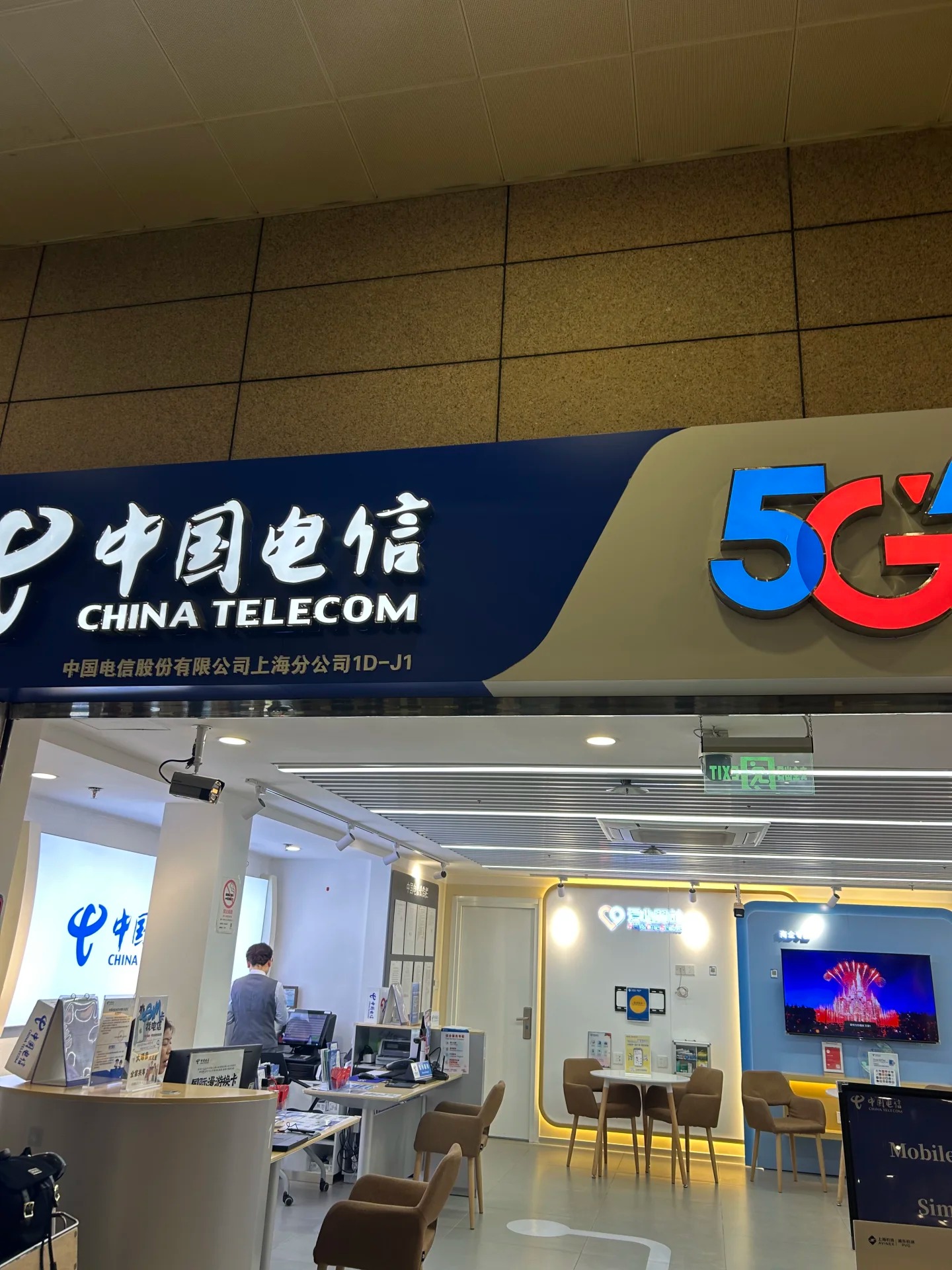 China Telecom 5G storefront at PVG T2 arrivals, unit 1D-J1, with an international roaming and SIM desk