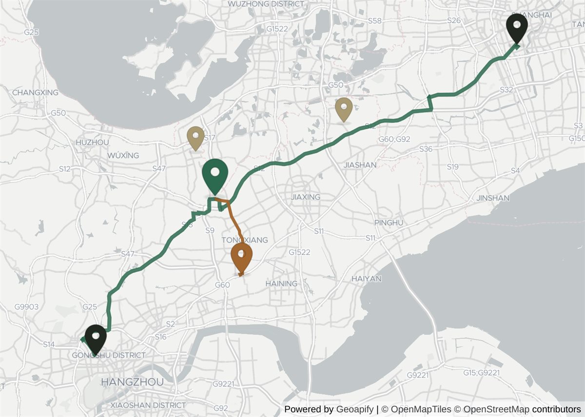Regional map of the Yangtze delta between Shanghai and Hangzhou. Wuzhen sits between the two cities and closer to Hangzhou — roughly 115 km by road from Shanghai and 75 km from Hangzhou — with a direct coach corridor marked from each city to the town itself. Tongxiang, the nearest railway station, lies about 29 km south-east of Wuzhen, and the road between that station and the town is marked separately, because that leg is the transfer a train arrival adds. Two other water towns are also marked for comparison: Nanxun, a short way north of Wuzhen, and Xitang, north-east of it and nearer Shanghai.