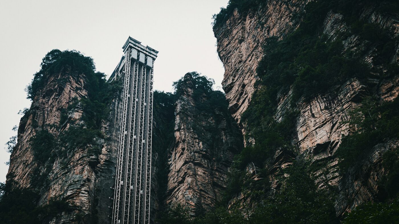 The Bailong Elevator — a glass-sided lift bolted to a sandstone cliff inside Zhangjiajie National Forest Park, rising to the Yuanjiajie plateau.