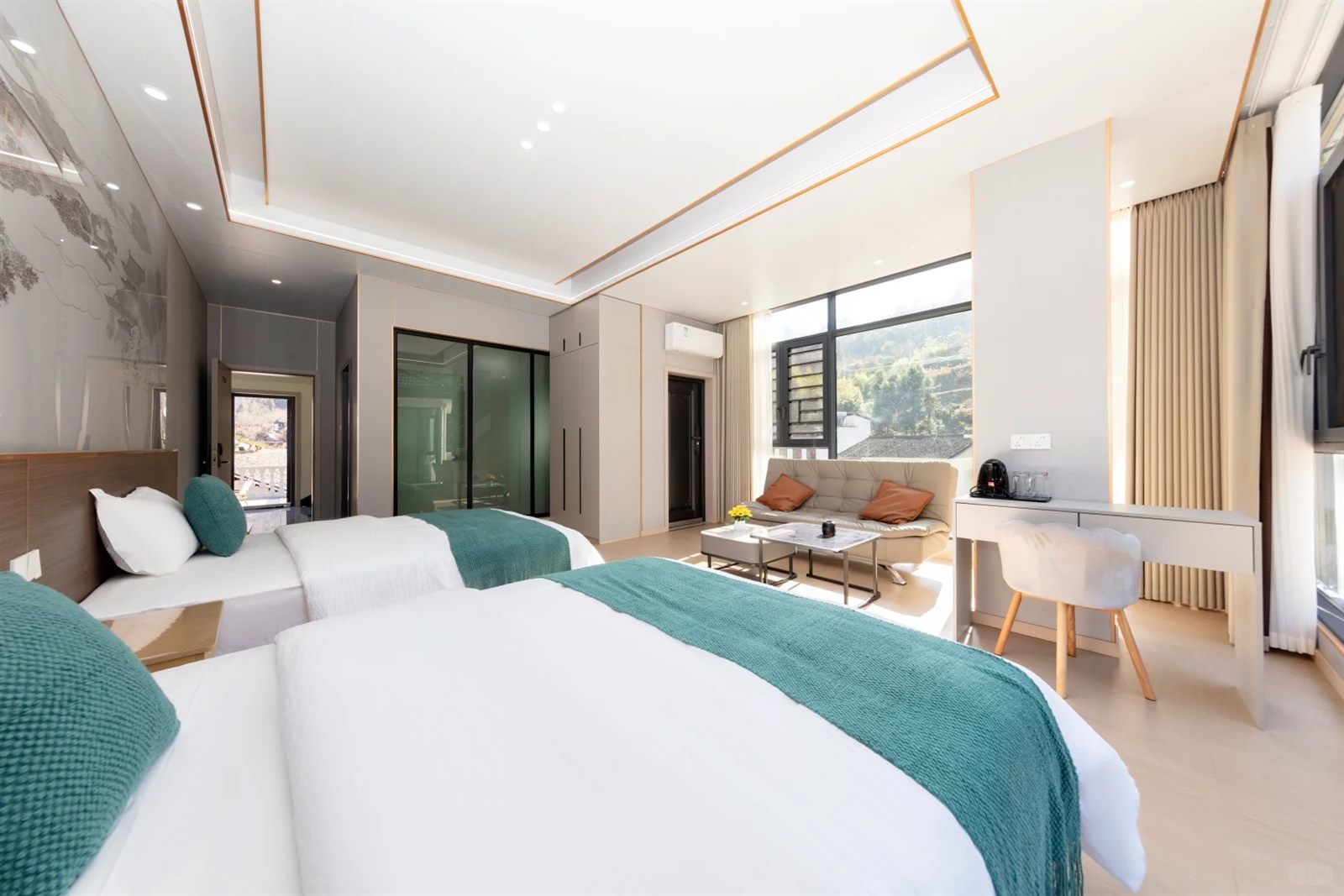 A twin room in a guesthouse inside the Zhangjiajie park area, with a window onto a wooded hillside village.