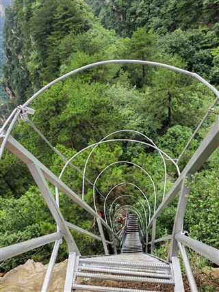 The caged iron ladder of One-Step-to-Heaven seen from the top, dropping toward the forest below, Yangjiajie, Zhangjiajie