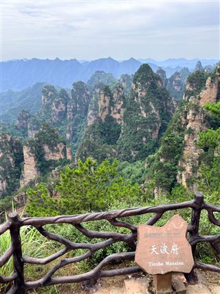 The Tianbofu overlook — the carved name stone at the railing and the peak panorama beyond, Yangjiajie, Zhangjiajie