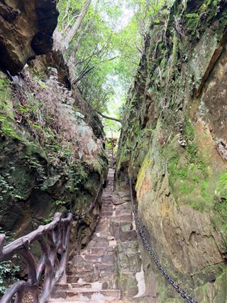 A chained stair squeeze between rock walls on the Wulongzhai trail, Yangjiajie, Zhangjiajie