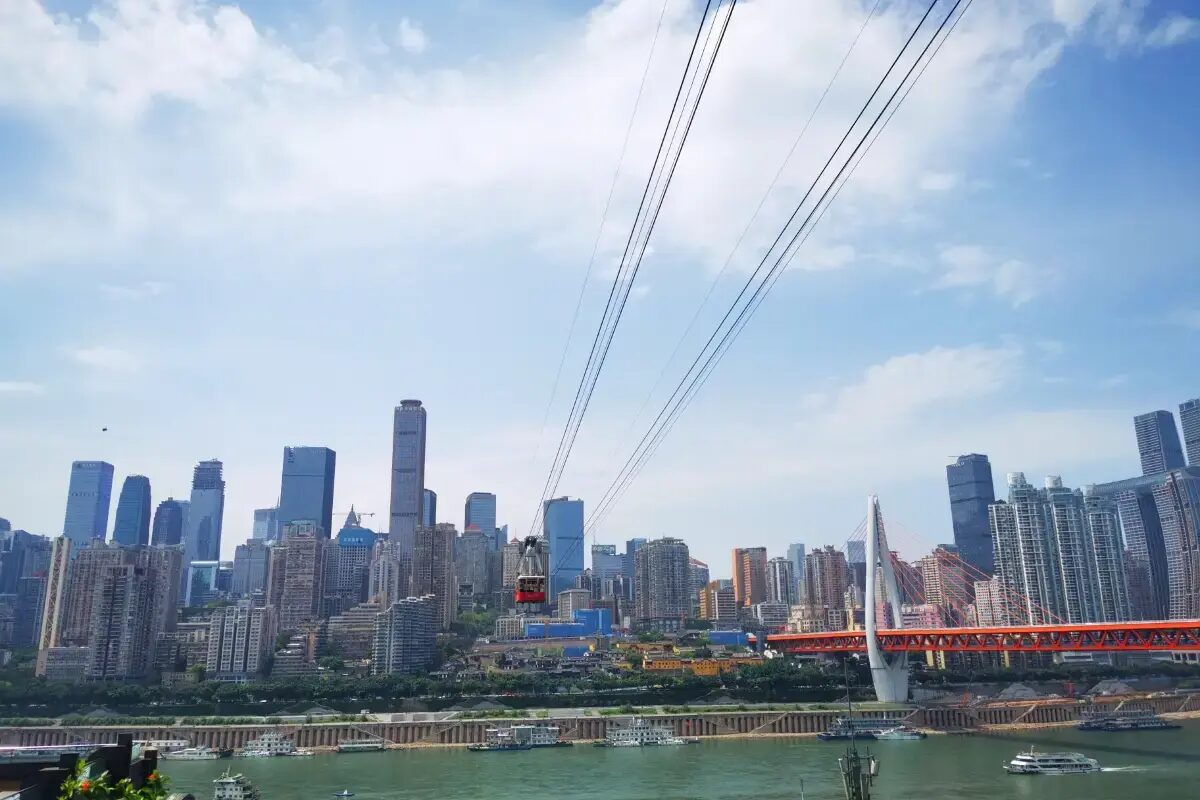 View toward the full Yuzhong Peninsula skyline as a Yangtze Cable Car cabin crosses the river, the south-to-north reveal.