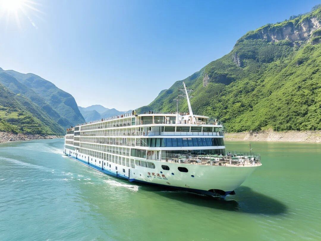 A Three Gorges cruise ship sailing through steep limestone cliffs on the Yangtze River near Chongqing.