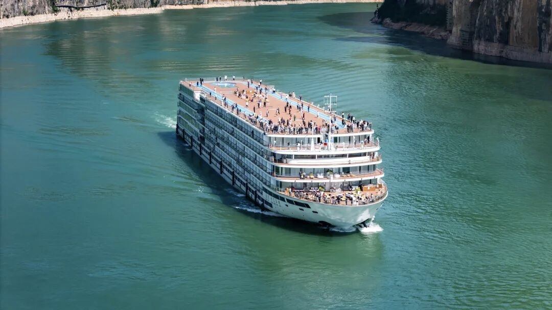 The sun deck of a Yangtze River cruise ship with passengers watching the Three Gorges scenery pass.