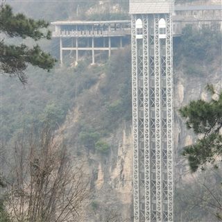The sightseeing lift tower standing against the cliff face of the Zhangjiajie Grand Canyon.