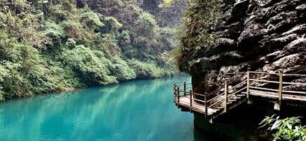 A clear stream and cliffside path on the Golden Whip Stream valley floor, Zhangjiajie.