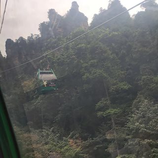 Huangshizhai cable car gondola over forested slopes